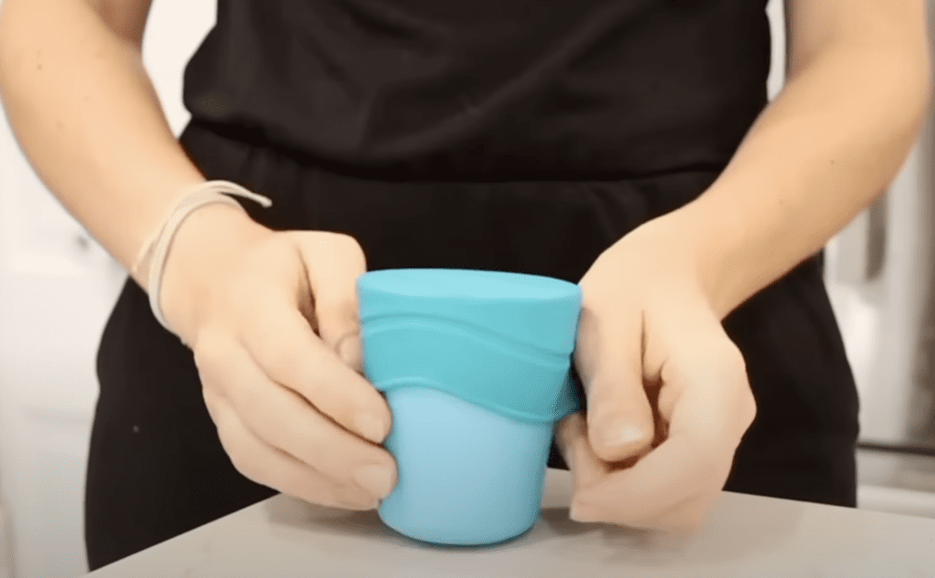 Mom using stretchy lid that fits over kid cup.