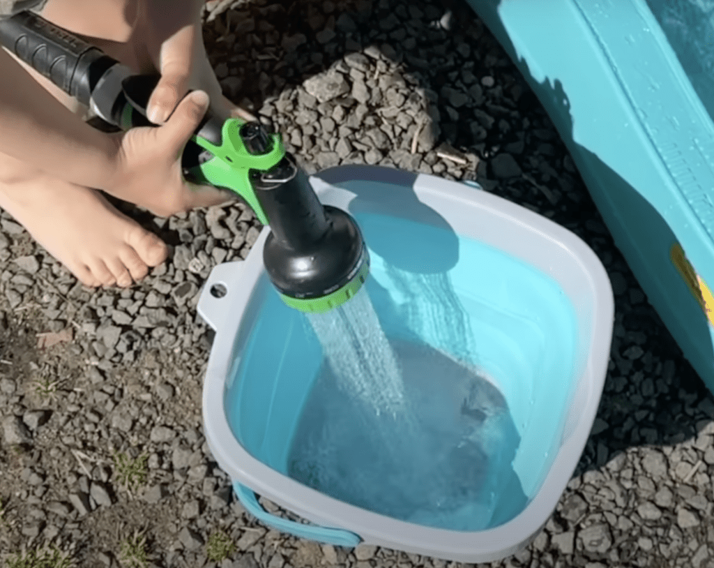 Silicon collapsible bucket being filled with water.